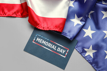 Paper sheet with text MEMORIAL DAY and USA flag on grey background