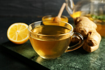 Teapot and cup of tea with ginger, honey and lemon, closeup