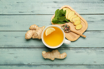 Cup of tea with ginger and mint on color wooden background