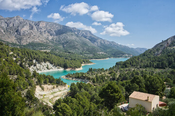 An idyllic lake between mountains. A famous city Guadalest reservoir in Alicante, Spain.
