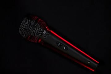 black microphone with red side floating in the air
