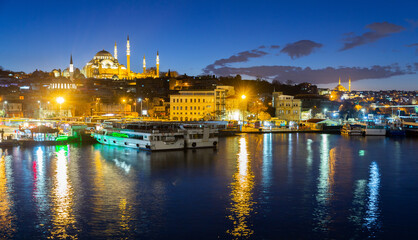 Fototapeta na wymiar Scenic night view of Fatih district on bank of Golden Horn bay with marina and lighted Suleymaniye Mosque, Istanbul, Turkey