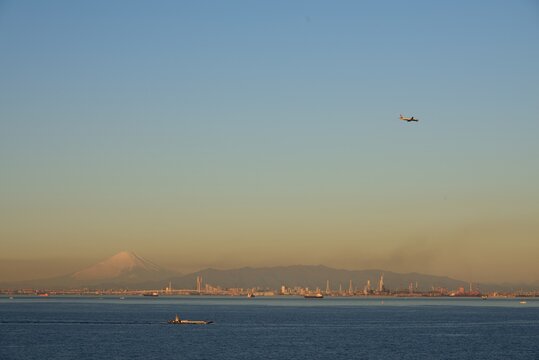 Airplane Flying Over Sea And Mt.fujiagainst Clear Sky