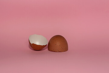 Eggs broken into two halves against a pink background.