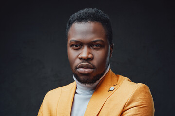 Obraz premium Isolated in dark background african dandy staring at camera
