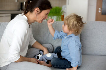 Mother, testing her child for covid at home, making home swab test to prove negative result, child trying to immitate mother