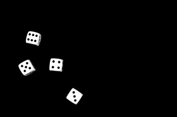 Top view of four dice on black background with space for text