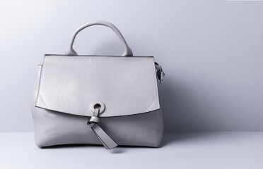 Women's bag of grey color, genuine leather. Grey painted wooden background