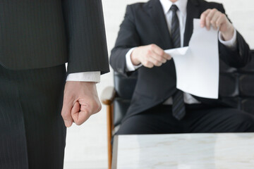 書類を破られ怒りを感じるビジネスマン