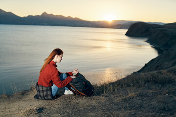 woman on vacation resting in the mountains near the sea at sunset