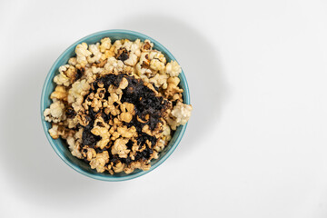 Burnt popcorn kernel in blue cup, place for text