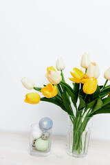 bouquet of yellow tulips and Easter eggs In a bright room Copy Space
