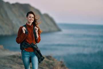 traveler with a backpack in the mountains in nature near the sea