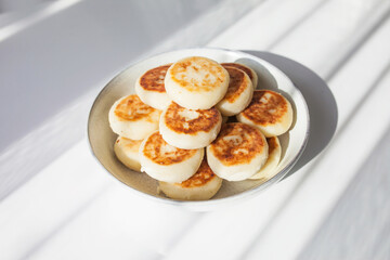 Plate of pancakes on the white table. Healthy breakfast or lunch. Sunlight and shadow. Copy space. Top view