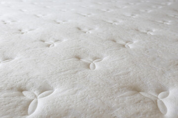 Close up shot of white orthopedic mattress surface pattern with a lot of copy space for text. Hypoallergenic foam matress for proper spinal alingment and pressure point relief. Background, top view.