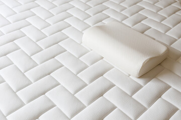 Close up shot of white orthopedic pillow and mattress pattern with a lot of copy space for text. Hypoallergenic foam matress for proper spinal alingment and pressure point relief. Background.