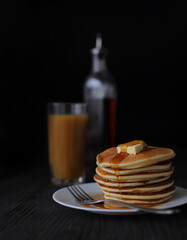 Sweet Homemade Stack of Pancakes with Butter and Syrup for Breakfast isolated on black background