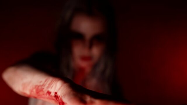 A demon girl with no pupils moves in the strobe light a bloody body