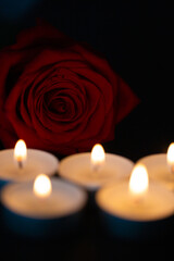 rote Rose mit Kerzen , schwarzer Hintergrund