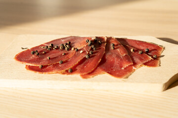 Slices of basturma on a cutting board, great appetiser and snack