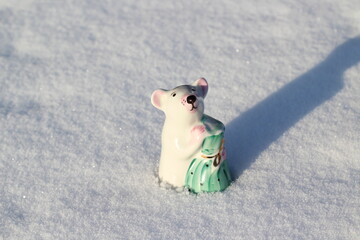 Mouse Symbol of Lunar Calendar Little Porcelain Figurine in Winter Snow. Small Statuettes of Cute Rat Holding Bag Full of Wealth and Health 