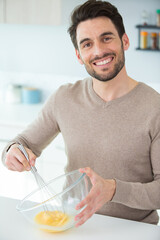man whisking eggs in bowl