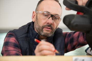 carpenter marking pine wood plank for cutting