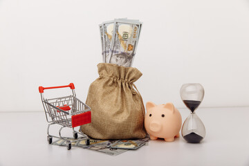 Dollar money bag, ohurglass and a shopping cart