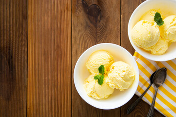 Vanilla ice cream scoops sundae in bowl on wooden background, copy space