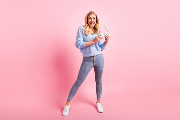 Full size photo of young happy positive dreamy smiling girl hold headphones look copyspace isolated on pink color background