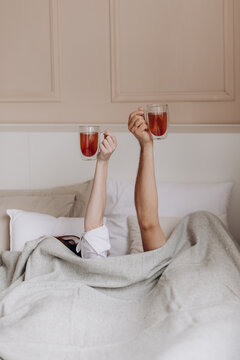 couple in bed with cups of tea, family morning, breakfast, weekend, love, relationship