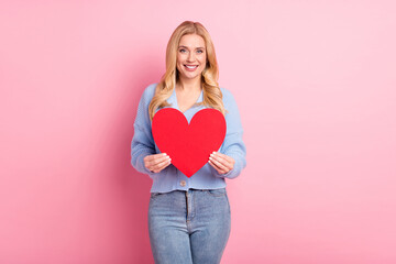 Photo portrait of woman pretty cheerful showing red heart love symbol isolated on pastel pink color background