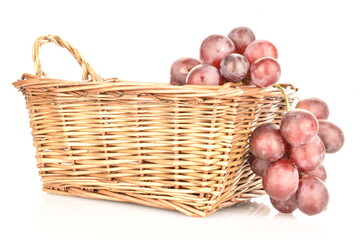 Obraz premium A bunch of fresh organic, juicy, ripe, sweet grapes with a wicker basket of vines, close-up, on a white background.