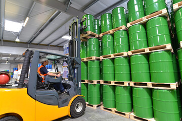 Transport und Logistik in der Chemieindustrie - Gabelstaplerfahrer mit Ölfässern // Workers in...