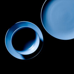 Multi-colored kitchen utensils of different shapes and sizes stand on a dark background