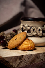 Fototapeta na wymiar Biscuits and a cup stand on a tree on a brown background