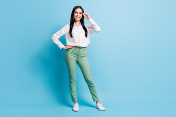 Full body photo of young attractive woman happy positive smile confident hand touch glasses isolated over blue color background