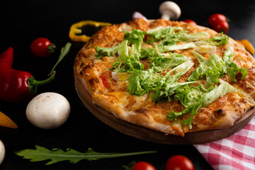 Caesar pizza on a white plate on a black marble