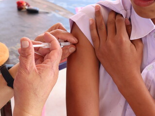 closeup of the doctor injecting the patient with the syringe in the hospital.