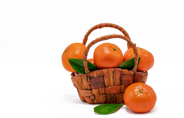 Ripe juicy tangerines in a wicker basket on a white background, close-up. Citrus fresh fruit. Free space.