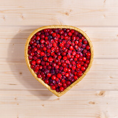 Heart-shaped cranberries on a warm wooden countertop.