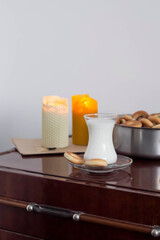 Candles, glass with milk and cookies on the table