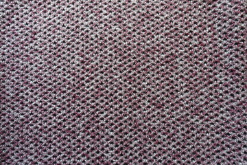 Top view of thick pink, grey and white woolen fabric with diamonds pattern