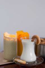 Candles, glass with milk and cookies on the table
