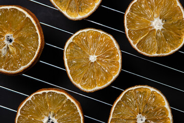 Dried orange slices on a black background. Dried orange on a dark background. Dried fruit.