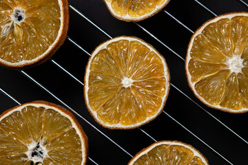 Dried orange slices on a black background. Dried orange on a dark background. Dried fruit.