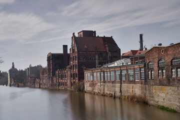Stare po przemysłowe budynki nad brzegiem rzeki w mieście Szczecin