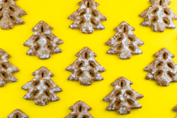 Christmas tree cookies on yellow background. New Year's food. Festive baked goods. Gingerbread on...
