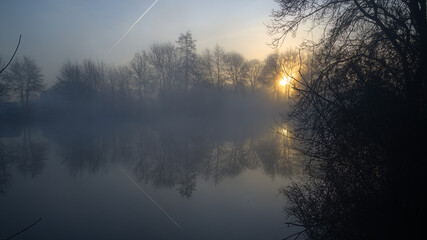 Brume sur le Loir au lever du soleil avec réflexion de trace d'avion dans le ciel et sur l'eau