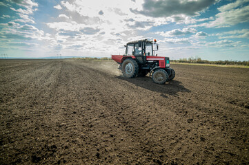 Obraz premium Tractor spreading artificial fertilizers